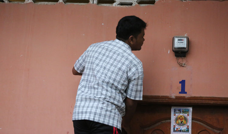 A man checks his power usage on his meter at his home in the capital. KT/Chor Sokunthea