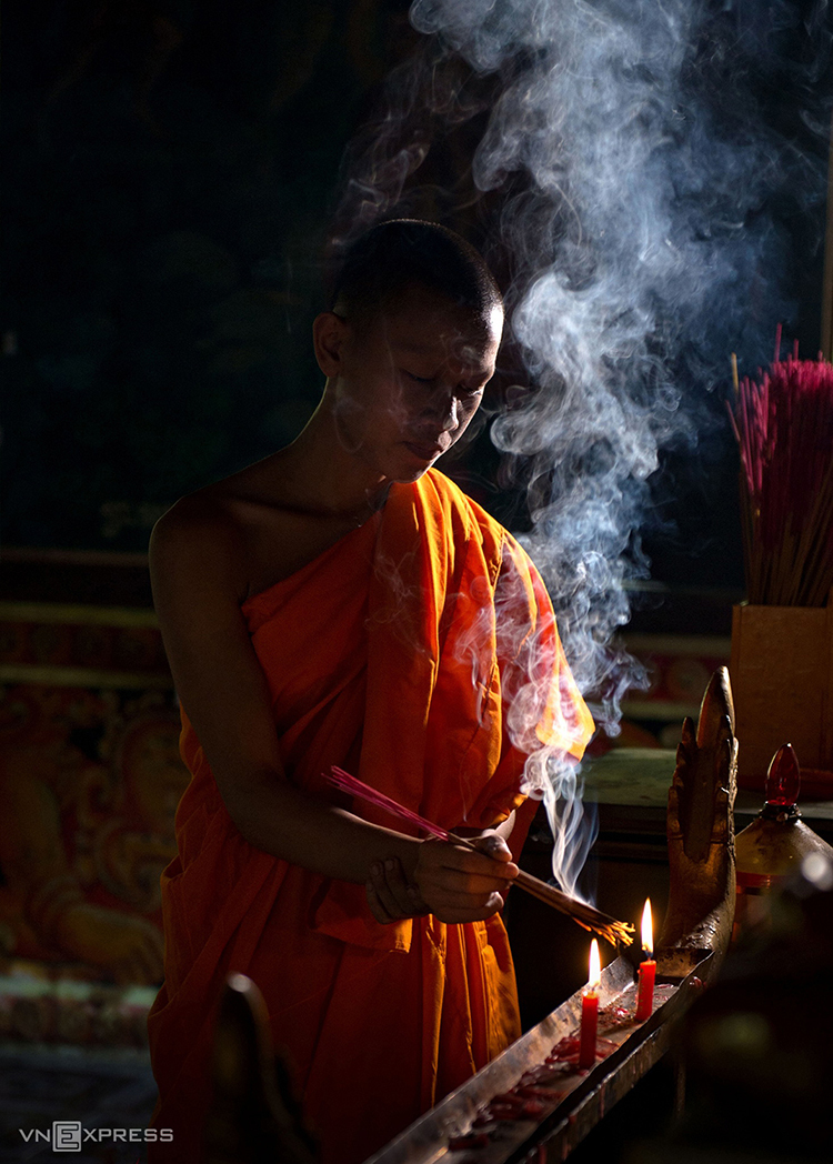 A novice monk burns incense inside the pagoda.
