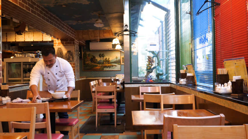 Culinary inheritance: Second-generation owner Shuji Go tidies the main dining room at Angkor Wat, which his father opened in 1982.