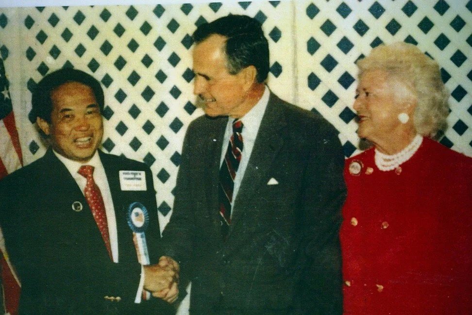 Ngoy (left) shakes hands with former President George Bush, pictured with wife Barbara, in 1991. Photo: Los Angeles Times via Getty Images